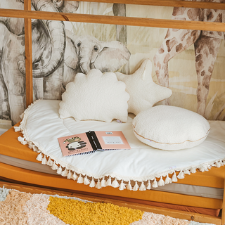 Minimalist cream boucle cushions with golden metallic detailing, enhancing the cozy vibe of kids room space.