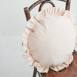 Close-up of the ruffled trim on the beige cushion, highlighting the soft fabric and delicate detailing